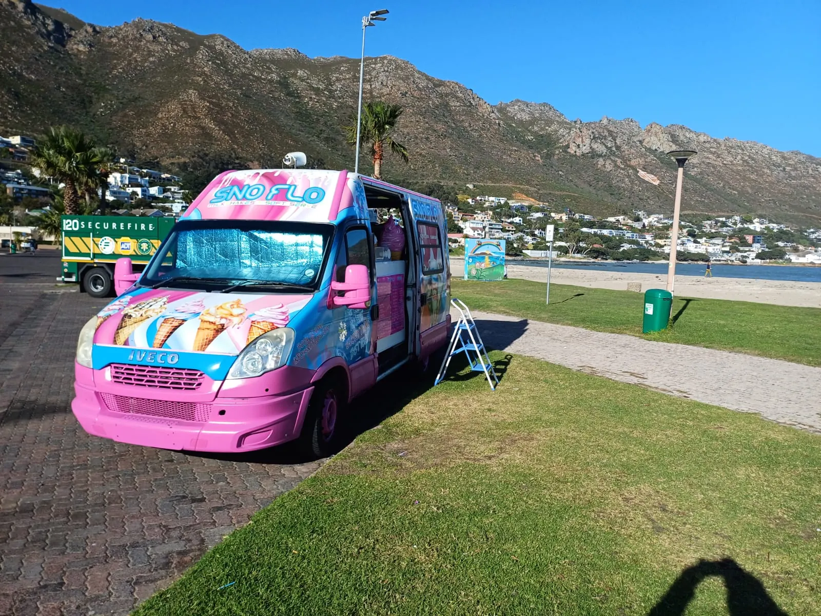 The SNO FLO bus parked on the grass at the seaside