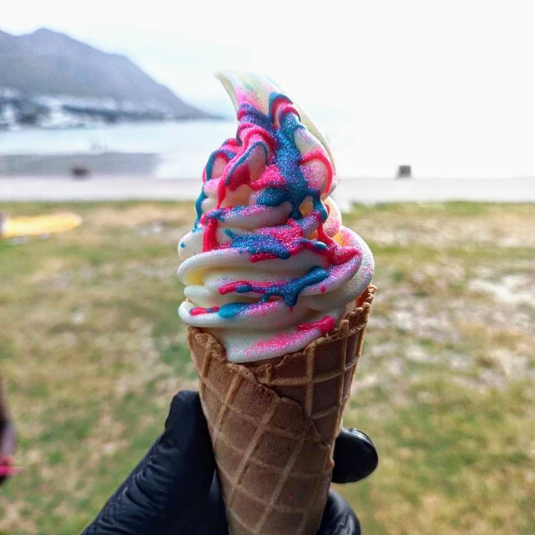 A pink-and-blue SNO FLO soft serve cone by the Cape Town coast